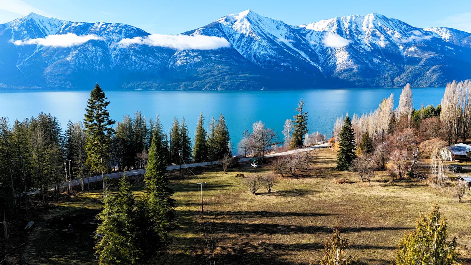 Acreage overlooking Kootenay Lake with snow-capped mountains